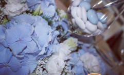 Centrotavola con fiori e confetti celesti.