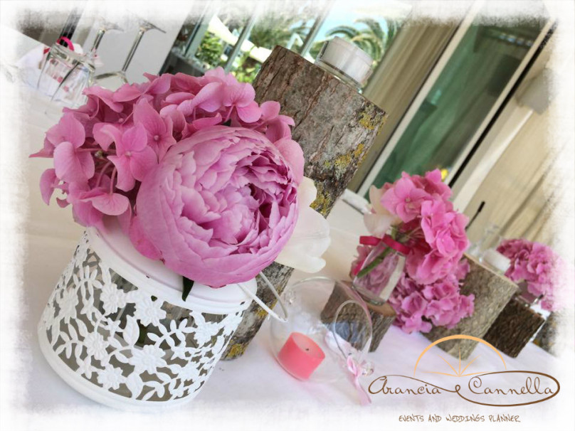 Tronchi, lanterne e peonie per il centrotavola.